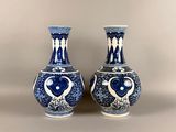 pair of blue and white vases sitting on top of a table