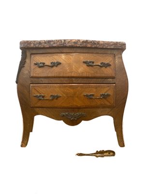 une petite commode en bois sur laquelle se trouve une clé