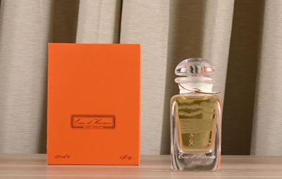 an orange box sitting on a table next to a bottle of perfume