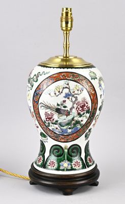 une lampe sur laquelle est représenté un oiseau, posée sur une table