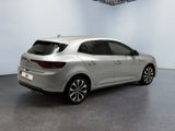 the rear end of a silver car in a white room