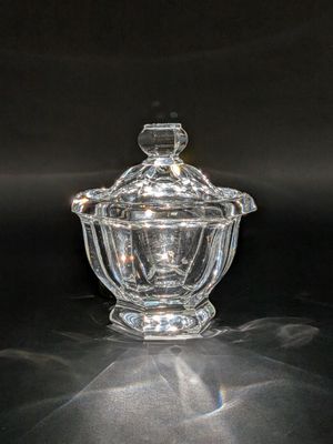un saladier en verre transparent muni d'un couvercle, posé sur une table