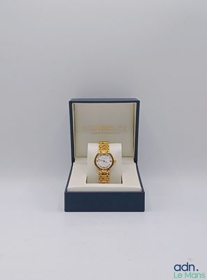a close up of a watch in a box on a white surface