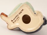 a small ceramic fish shaped object with writing on it