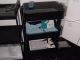 a black cart with a computer on top of it in a room