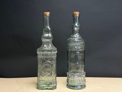 deux bouteilles en verre vides posées l'une à côté de l'autre sur une table