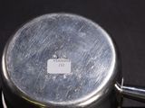 a silver pot sitting on top of a stove