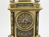 a gold clock sitting on top of a table