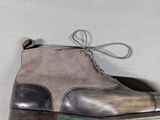 someone is holding a pair of shoes that are on a wall