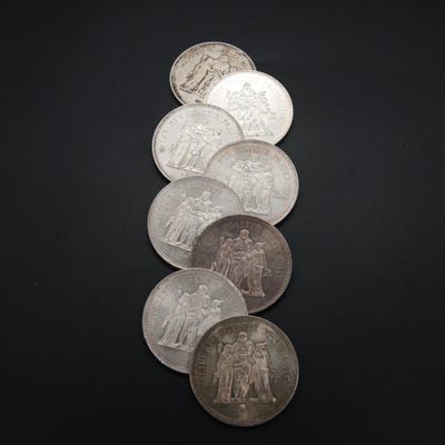 six types différents de pièces d'argent sur une surface noire