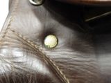 a close up of a brown leather bag with a button
