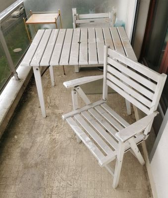 chairs and a table on a balcony with a view of the ocean