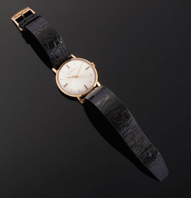 a close up of a watch on a black surface