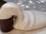 a cup of ice cream sitting on a table next to a cup of coffee