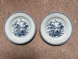 two blue and white plates with flowers and birds on them