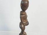 statue of a woman holding a baby in her arms on top of a clear shelf