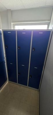 une rangée de casiers bleus dans des toilettes publiques
