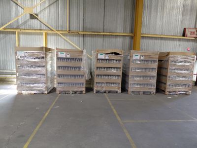 plusieurs piles de cartons contenant des articles divers dans un entrepôt