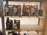 de nombreuses bouteilles d'huile moteur sur une étagère dans un garage