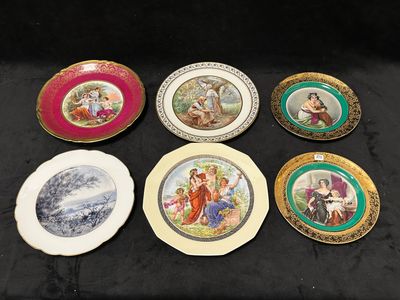 six assiettes ornées de motifs différents, posées sur un support noir