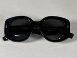 une paire de lunettes de soleil noires posée sur une table blanche
