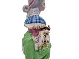 an image of a figurine of a woman with a hat and a dog