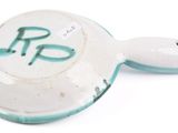 a white and blue bowl with a spoon on it