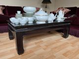 a coffee table that has a lot of dishes on it