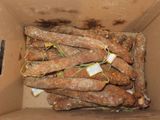 a cardboard box full of sausages with tags on them