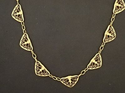 gros plan d'un collier en or sur une surface noire