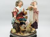 figurine représentant un homme et une femme assis sur un banc