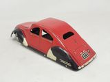 a red toy car that is sitting on a white surface