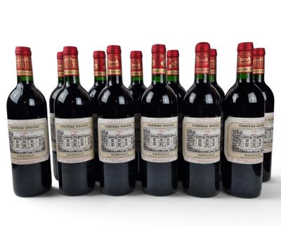 six bottles of red wine lined up in a row on a white surface