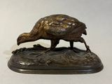 a bronze statue of a pheasant on a base