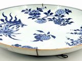 a large blue and white bowl with flowers and birds on it