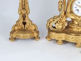 two gold clocks sitting next to each other on a table