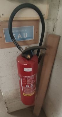 un extincteur fixé au mur d'une pièce