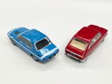 two toy cars sitting next to each other on a white surface