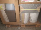 many rolls of plastic sitting on a pallet in a warehouse