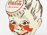 a paper cutout of a boy with a coca cola cap on his head