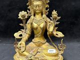 une statue en or représentant une femme assise sur une table