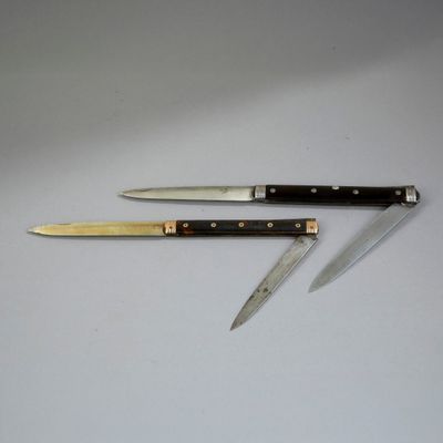 two knives on a table with a knife holder on top of it
