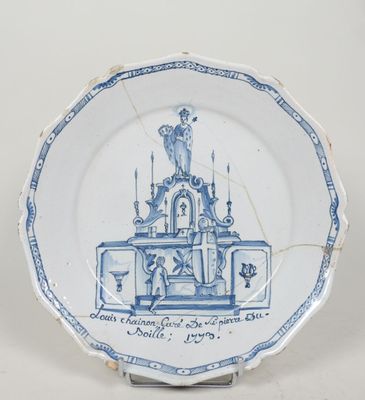 une vieille assiette bleue et blanche sur laquelle est représentée une église
