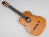 a small wooden guitar sitting on top of a white surface