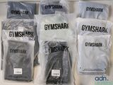 Six sacs contenant des articles Gymshark sont posés sur un comptoir.