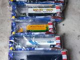 six petits trains en plastique, rangés dans des sachets, alignés sur le sol
