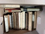 a cardboard box filled with old books on the floor
