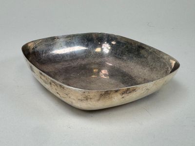 a silver bowl on a table with a white background