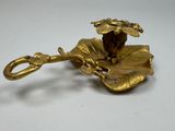 brass plate with a flower on it on a white surface