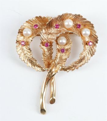 une image représentant une broche en or ornée de perles et de pierres roses